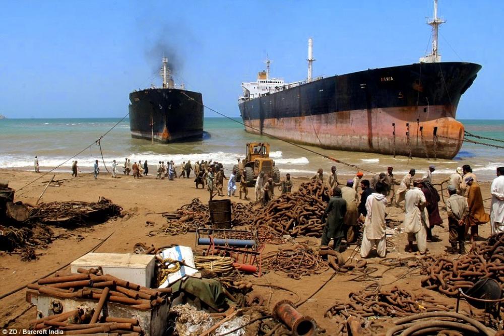 Navires échoués et en cours de démantèlement alignés sur la plage d’Alang, en Inde.